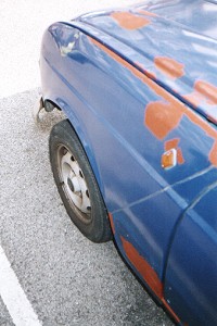 The dent remains, but several other small rust patches and holes have been filled