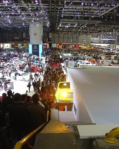 View from the top of the staircase looking across the lower floor of the Motor Show, with the half-R4's headlight beaming up at passing visitors